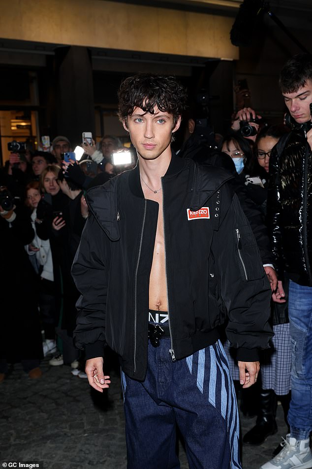 Troye changed into a pair of baggy indigo jeans that featured a large light blue graphic stripe in a chevron pattern.