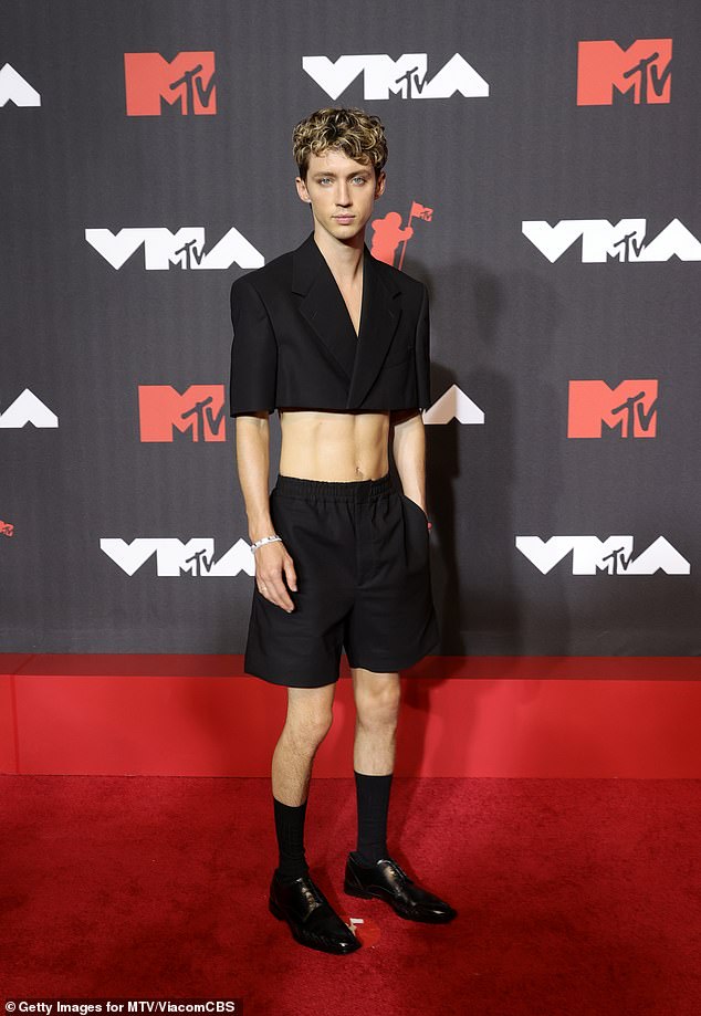 Troye is known for his striking and bold ensembles, including a low-cut bodycon dress at the Met Gala in 2021, as well as his cropped blazer and shorts combo at the 2021 VMAS.