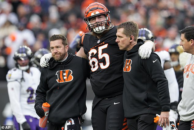 Bengals guard Alex Cappa gets help from Cincinnati medical staff to get off the field against the Ravens.