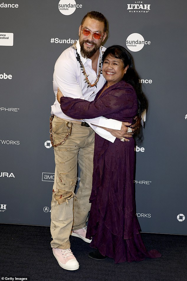 Sweet hug: Momoa gave a big hug to the former first lady of the Palau Debbie M. Remengesau, who was wearing a long purple dress