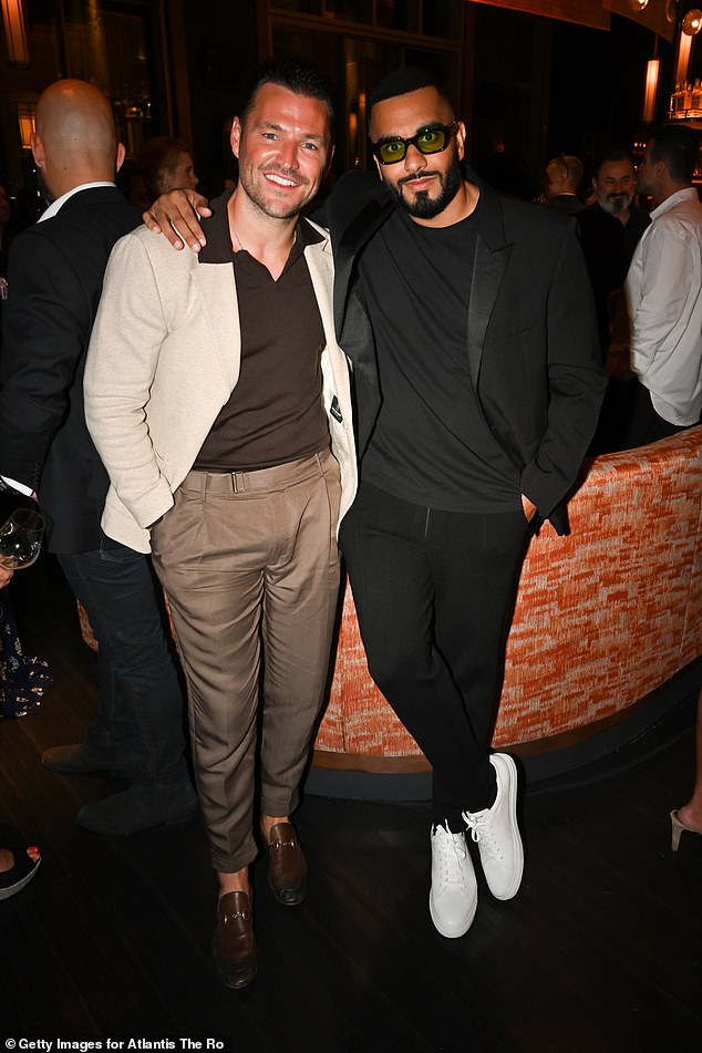 Dapper: Her husband Mark looked dapper as he rocked an all-brown outfit and posed for a photo with his long-time friend and Pretty Little Thing founder Umar Kamani