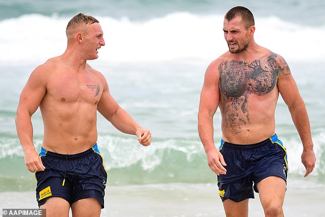 Spry will get the chance to play NRL alongside new Titans teammates Tanah Boyd and Kieran Foran, pictured taking part in a recovery session on North Burleigh beach.