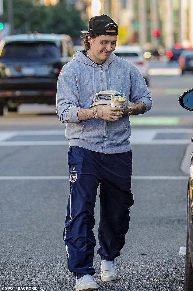 Cool but casual: Brooklyn looked like the perfect piece to dress up on Friday when she dressed casually for the sunny day ahead, opting for a light gray hoodie with the sleeves rolled up.