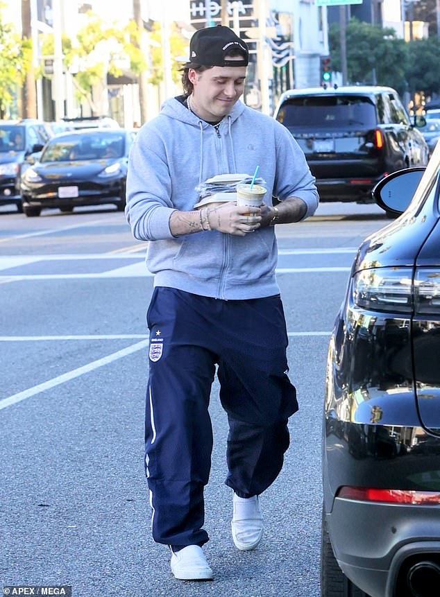 Feeling hungry: Brooklyn looked ready to eat his tasty lunch as he headed to his car