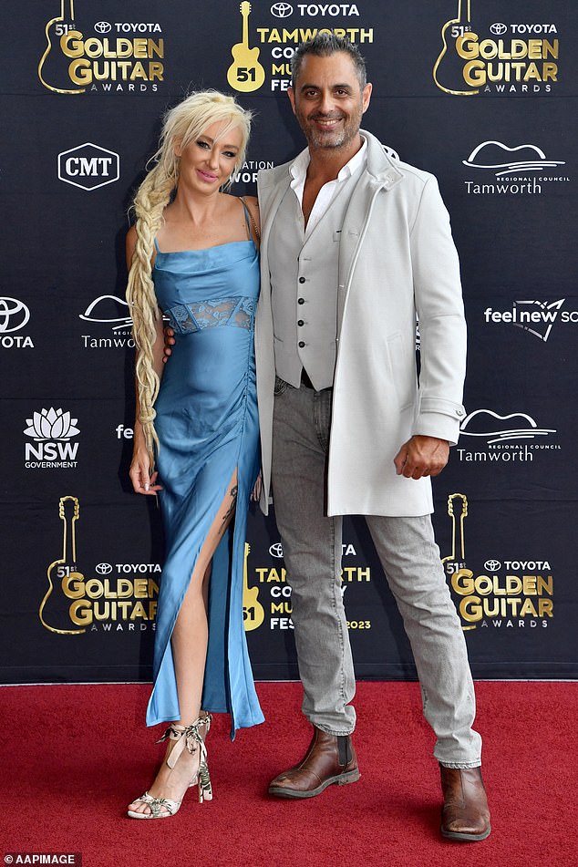 Folk singer Kylie Whitney (left) looked great in baby blue satin with lace details and a high slit as she posed with her date.