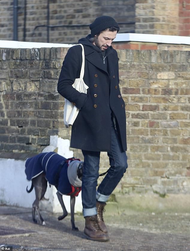 Relaxing: The TV presenter looked downcast while wearing a black knitted beanie and a short trench coat to ward off the winter chill