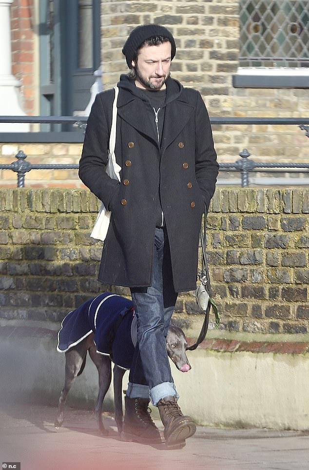 Cute: Her pet, Simon, was dressed in an adorable navy blue fleece-lined coat for his chilly walk.