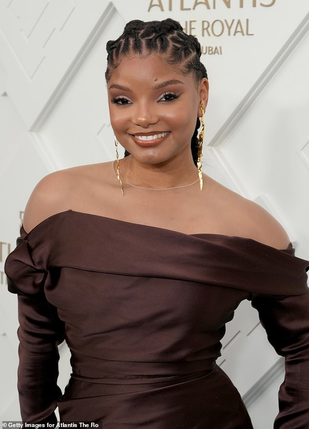 Accessories: Elaborate gold earrings dangled from her ears, coming close to her clavicle as she posed on the red carpet.