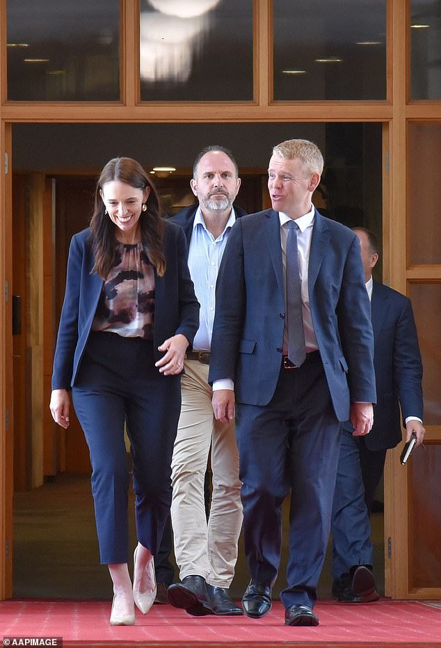 New Zealand Prime Minister Jacinda Ardern (left) and new Labor leader Chris Hipkins (right) enter Parliament House in Wellington before party MPs unanimously approved the change.