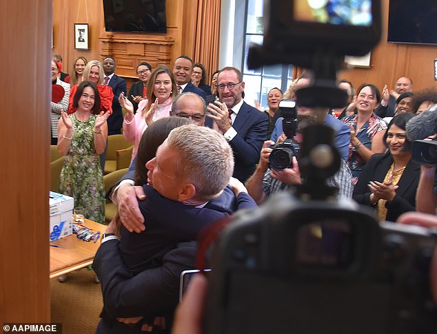 New Zealand Prime Minister Jacinda Ardern and new Labor leader Chris Hipkins embrace in front of the press before Mr Hipkins was installed as the party's new leader.