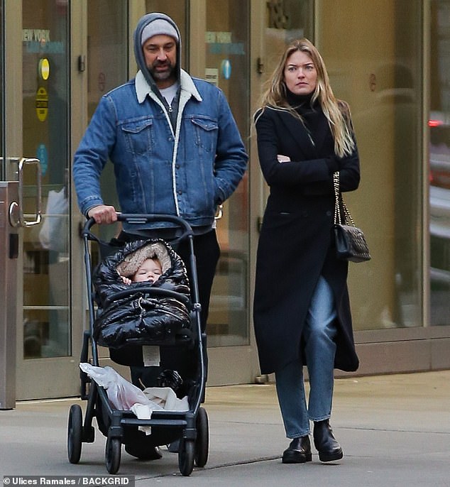 A family outing: The model bundled up in a fitted double-breasted coat as she and the photographer, 36, took turns pushing their one-year-old daughter, Emery, in a stroller.