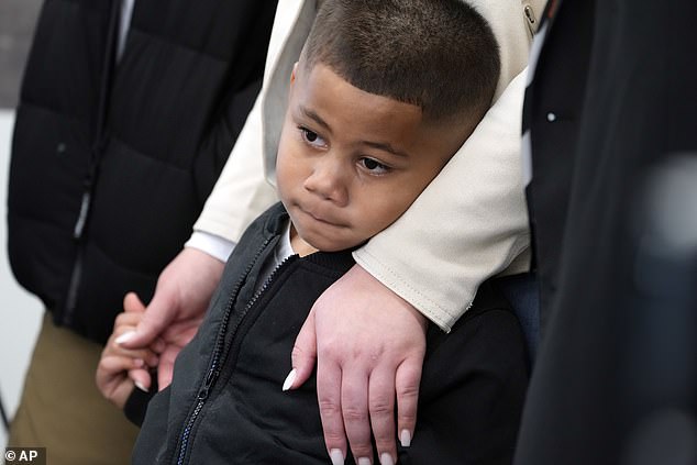 Syncere Kai Anderson, 5, is held by his mother, Gabrielle Hansell, at a news conference.