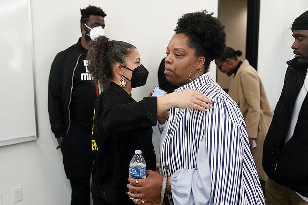 Melina Abdullah, left, hugs Patrisse Cullors, right, co-founder of the Black Lives Matter movement, at the press conference.