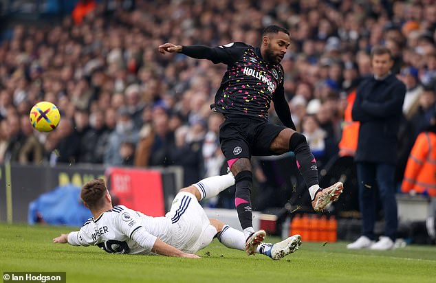 Brentford's Rico Henry leaps over a challenge from Leeds' Max Wober during the first half