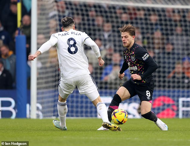 Leeds' Marc Roca and Brentford's Jensen battle for the ball at midfield at Elland Road