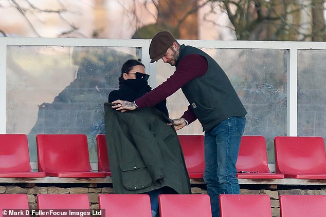 Couple: David Beckham was ever the gentleman when he gave his wife Victoria his coat as they watched their son Romeo's match in Burton upon Trent on Saturday