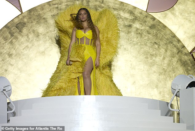 Stunning: The Halo singer, 41, looked stunning in a bright yellow corseted gown with feathered angel wings  The Dreamgirls star showed off her taut abs through sheer panels and showed off her toned legs with the help of some hip-length slits in her dress.