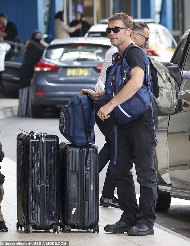 The couple, returning to the United States after a short trip to Sydney, seemed to have their hands full as they carried their bags through the terminal and kept an eye on their children.