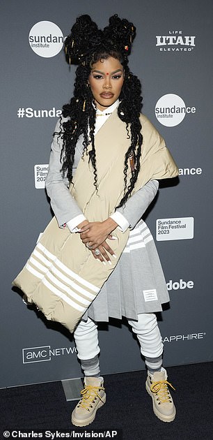 Commanding the spotlight: The singer coordinated with her husband and daughters, wearing an over-the-chest beige puffer and pleated gray skirt with a matching blazer