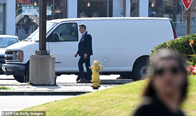 A law enforcement officer walks past a body slumped in the driver's seat of a pickup truck in Torrance, California, on Sunday after a confrontation with police.