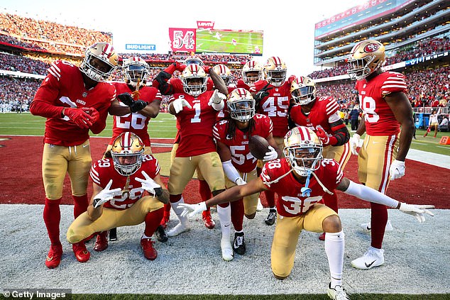 Warner and the 49ers defenseman pose for a photo in the back of the Cowboys end zone