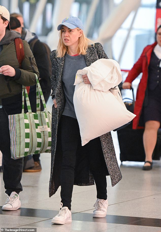 Heading home: Grabbing a pillow and wearing minimal makeup, the White Lotus star, 38, kept it cozy and casual for her day of travel