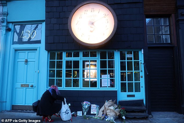 A supporter leaves flowers outside British designer Vivienne Westwood's Worlds End store in Chelsea, west London, on December 30, 2022.