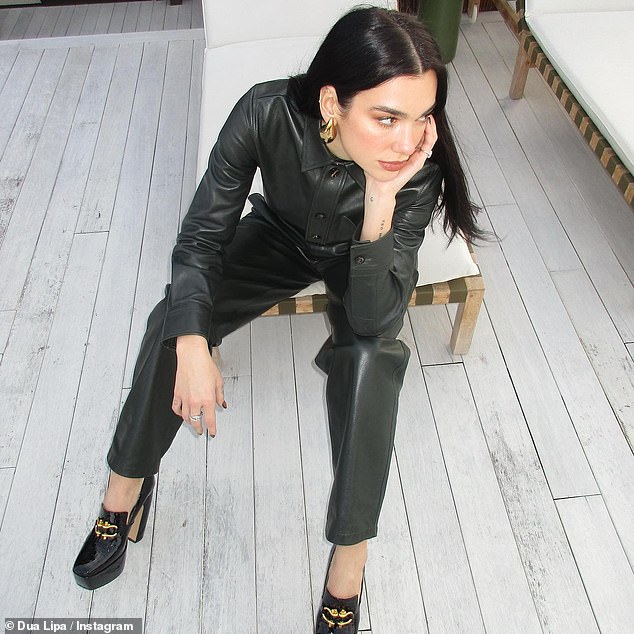 Hot stuff: The singer looked chic in a black leather jumpsuit and black platform heels