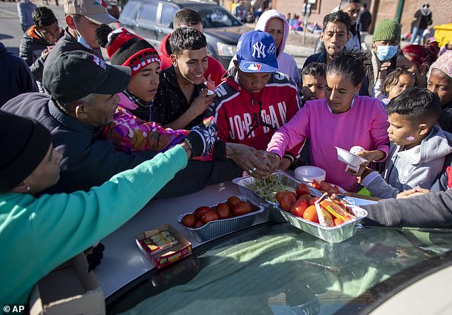 The unprecedented influx of migrants left Yuma on the brink of collapse and hospitals and food banks overwhelmed.  Pictured: Migrants serve food donated by a resident at the southern border, December 21, 2022