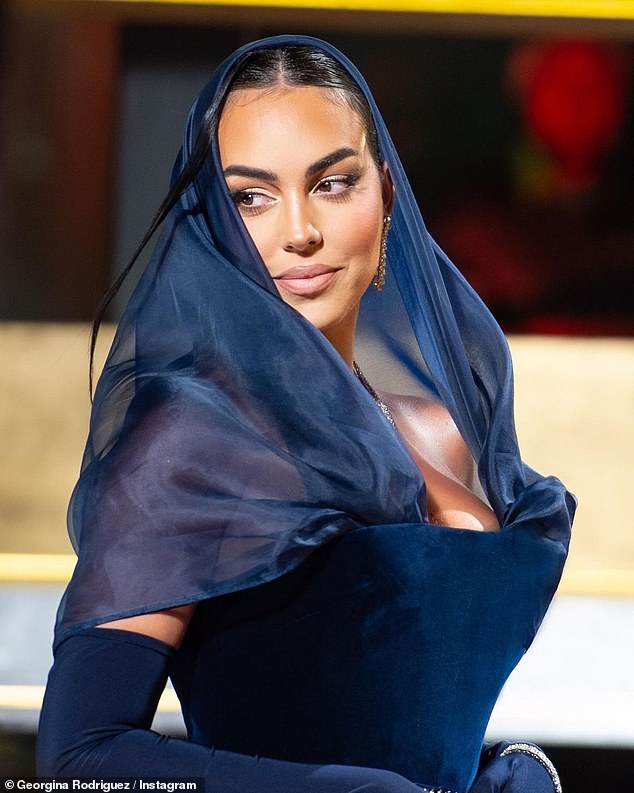 Scarf: A layer of satiny material draped her head and shoulders before plunging into the strapless neckline.