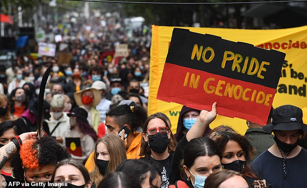 People carry banners as thousands attend an Australia Day protest in Melbourne in