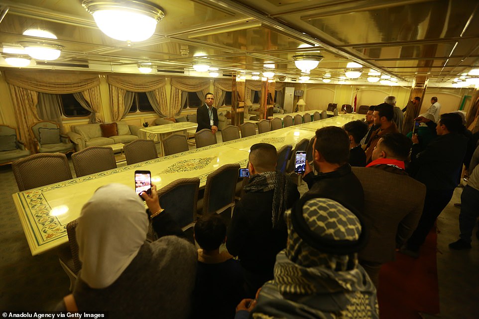 Visitors to the yacht took photos of the long dining table, which seats more than 30 guests, in a room with low ceilings and views of the sea.