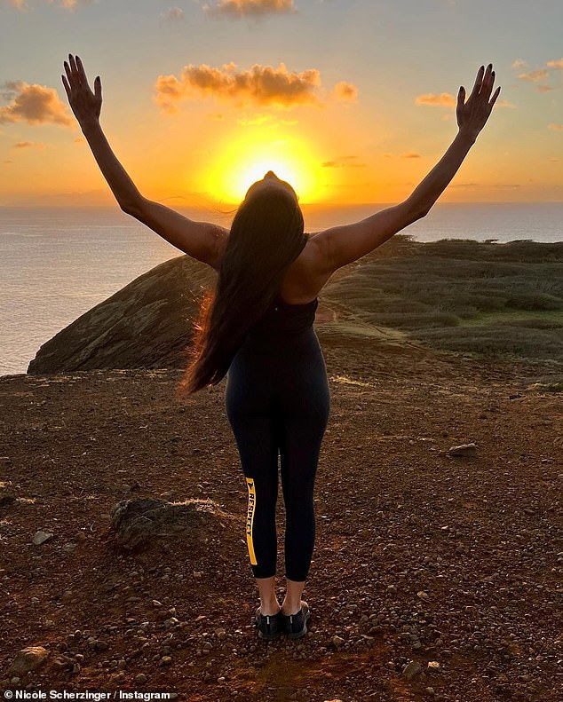 Pose: Nicole leaned back into another stretch as the sun rose behind the sea in front of her.