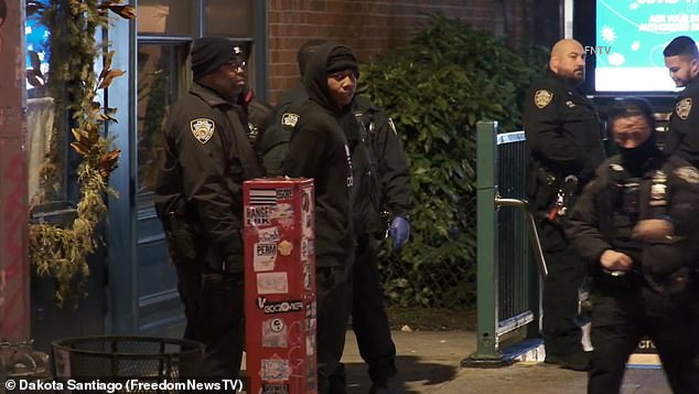 One of the teens looks into the camera as officers handcuff him at the 18th Street station.