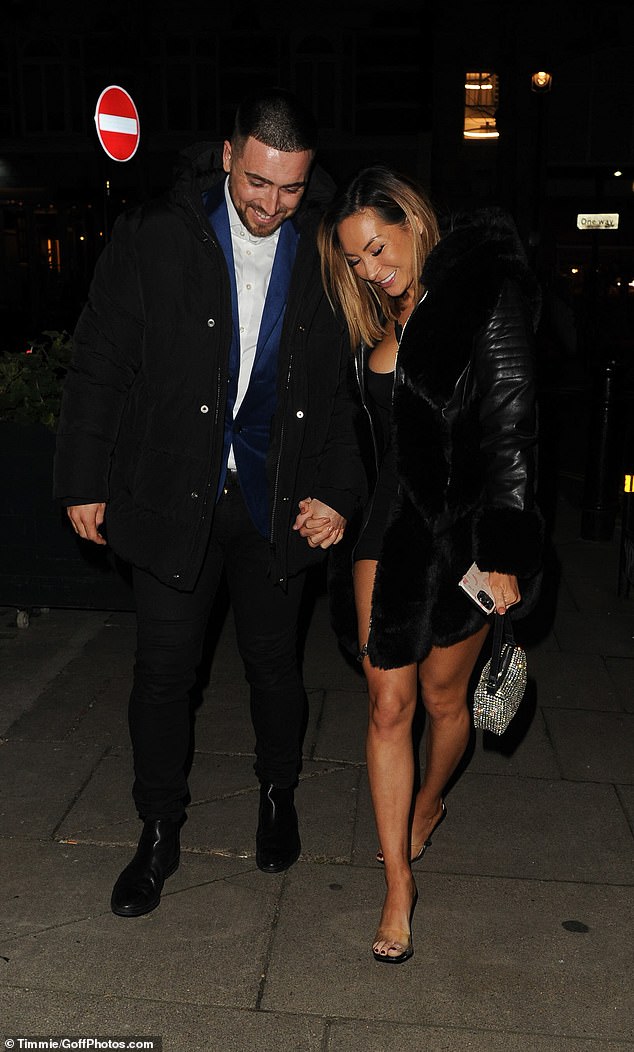 Adorable: The former Love Island star was beaming as she reached out to her boyfriend as he left the 18-50 restaurant in Oxford Circus, London