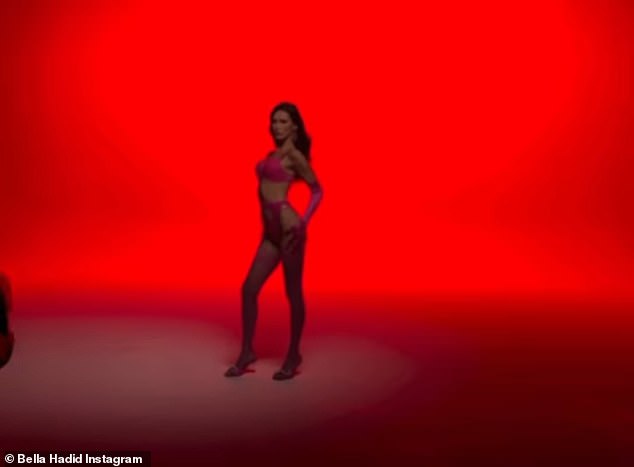 Dramatic Lighting: A second clip showed her arching her back and raising one leg dramatically while bathed in shadows against a red backdrop.  But then a spotlight went on above her, illuminating her figure as the camera panned back.