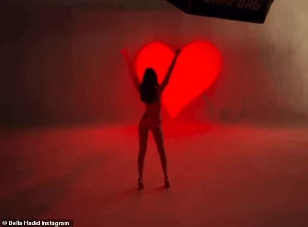 Stretching: Bella completed her carousel with a video of her posing from behind and raising her arms triumphantly in front of an illuminated heart on the far wall.