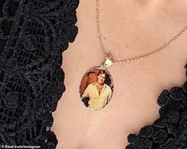 Eagle-eyed followers noticed that Bindi was wearing a pendant necklace with a photo of her late father Steve Irwin inside (pictured).