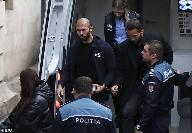 Andrew Tate (center) and his brother Tristan Tate (second right) are escorted by Romanian police officers inside the Court of Appeal, Bucharest, Romania, January 10, 2023.