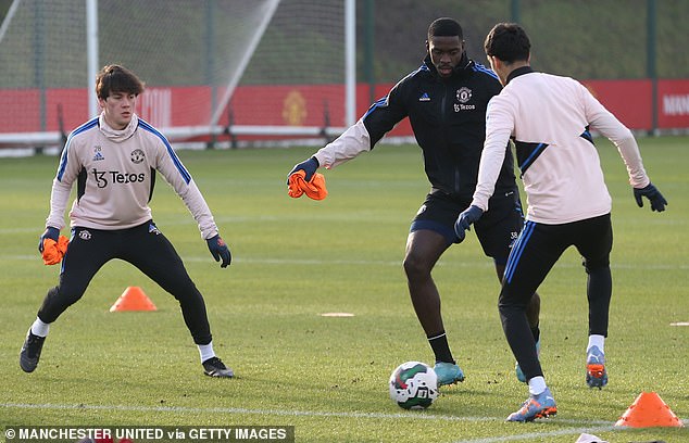 The defender is pressured by Facundo Pellistri (left) during a drill in Carrington on Monday.