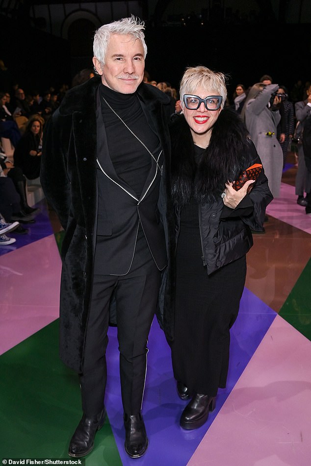 Matching: Baz opted for a black suit and t-shirt under a black faux fur coat, while Catherine Martin wore black pants and a matching jacket with a hint of bright red lipstick