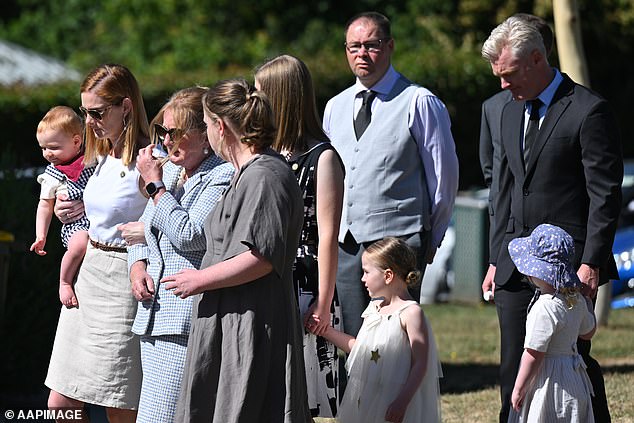 Distraught loved ones, including Senator Molan's wife, are seen at his funeral in Canberra.