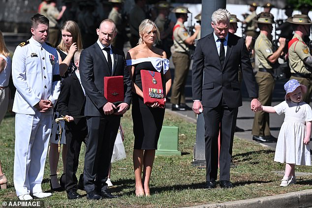 Erin Molan is seen holding her father's medals at his funeral in Canberra on Wednesday.