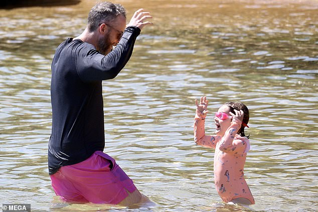 The super-rich Blakes enjoyed drinks and snacks on the shore, before joining their kids for a dip in the ocean.  (Hamish is pictured with his daughter Rudy)