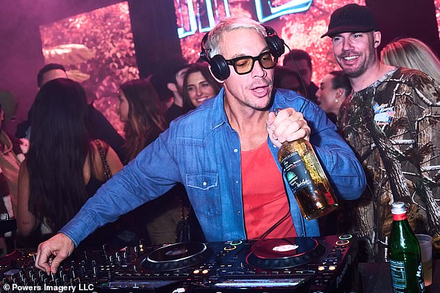 On trend: Diplo, 44, rocked a denim shirt over a bright red T-shirt