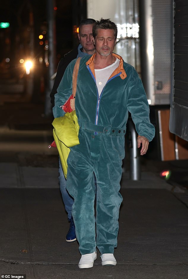 Footage: Brad changed into a pair of white slip-on shoes, while carrying a large bag and a green blanket.