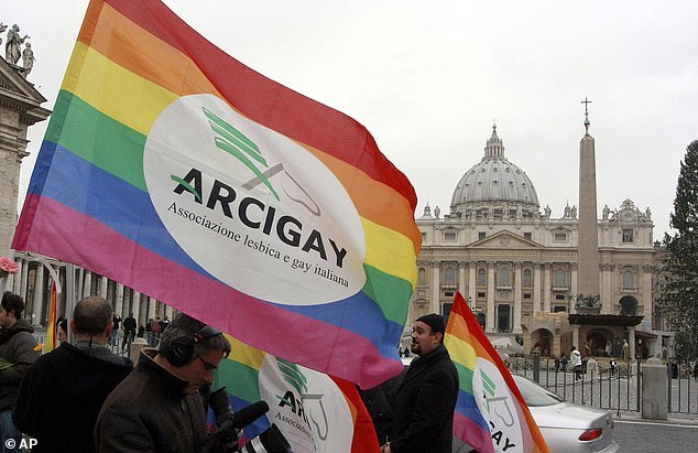 A gay rights organization waves a rainbow flag during a protest outside the Vatican.