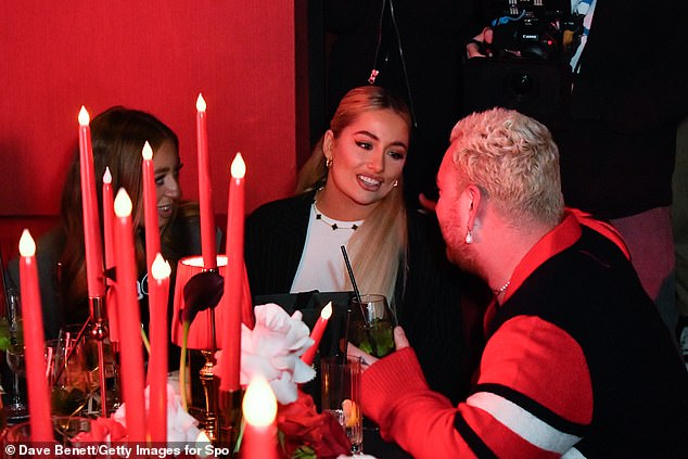 Looking good: The superstar wore nothing under her red and white patterned cardigan and jeans and completed her look with Timberland boots