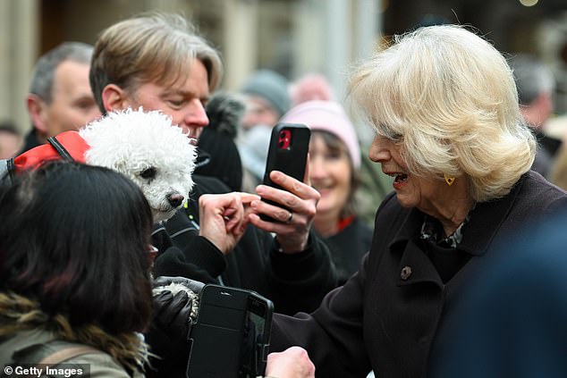 The queen consort waved a dog's paw through the crowd after her visit to the Royal Osteoporosis Society reception at the Guildhall.