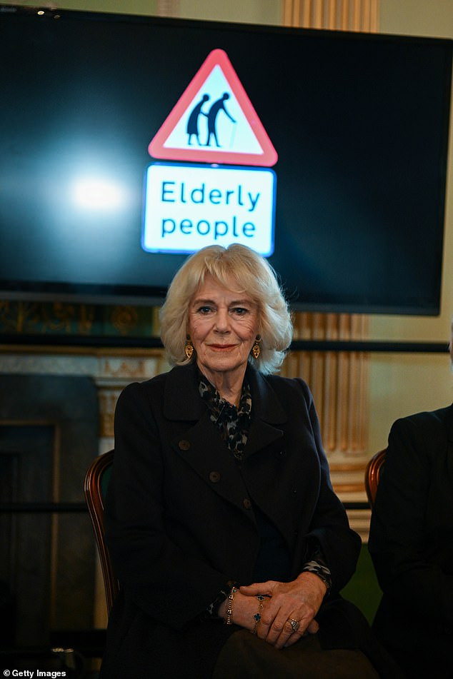 Camilla sat in front of a sign reading seniors during the performance at Guildhall.
